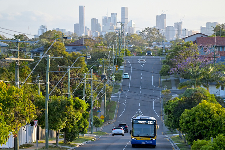 Brisbane street with traffic, powerlines, and cityscape